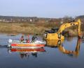 Bild: Laube
Nach einem technischen Defekt an der Hydraulikleitung steckt der Bagger im Regen fest. Einsatzkräfte der Feuerwehr Roding sichten das Umfeld vom Rettungsboot aus.