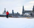 Bild: Robert Michael/dpa
Eine Frau läuft am verschneiten Elbufer vor der historischen Altstadtkulisse in Dresden Ski