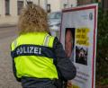Archivbild: sbö
Eine Polizistin bringt im Oktober 2025 ein Fahndungsplakat in der Nähe des Wernberger Marktplatzes an.
