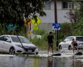 Bild: Stephen Lam/San Francisco Chronicle via AP/dpa
Zwei Jugendliche surfen in Waialua neben einem liegengebliebenen Fahrzeug im Hochwasser.