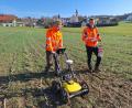 Bild: bl
Lukas König (links) schiebt das Bodenradar übers Feld, sein Studienkollege Jonas Müller setzt die großen Stecknadeln, die Fixpunkte auf dem Gelände markieren.