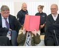 Bild: Bernd Wüstneck/dpa
Die Angeklagte sitzt mit Aktendeckel vor dem Gesicht zwischen ihren Verteidigern Andreas Ohm (l-r) und Thomas Löcker.