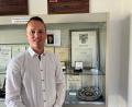 Bild: ihl
Der neue Bürgermeister von Schmidgaden, Martin Bauer, steht vor der Vitrine im Eingang zum Rathaus. Im Hintergrund ein Bild seines Urgroßvaters Josef Bauer. Er war ebenfalls Bürgermeister von Schmidgaden und ist Ehrenbürger. Martin Bauer heißt mit zweitem Vornamen Josef wie sein Urgroßvater.
