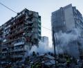 Bild: Evgeniy Maloletka/AP/dpa
In den Trümmern eines bei einem russischen Angriff teils zerstörten Hauses suchen Helfer nach Verschütteten.