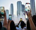 Bild: Fatima Shbair/AP/dpa
Eid al-Adha in Dubai: Besucher fotografieren den Brunnen vor der Skyline