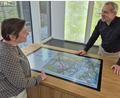 Bild: Lowak
Im Foyer des Landesamtes für Digitalisierung, Breitband und Vermessung, Außenstelle Windischeschenbach, gibt's auf einem großen Tisch Einblicke in den Bayern-Atlas. Chefin Daniela Schleder und Referatsleiter Johann Sehner zeigen, welche Funktionen dieses Portal bietet.