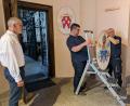 Bild: Paul Zrenner
Beim rechten Seiteneingang zur Basilika wurde ein geeigneter Raum für die Papstwappen-Galerie gefunden. Von links Pfarrer Dr. Thomas Vogl zusammen mit Mesner Dominik Sirtl und Johann Schnur, die die Wappen am Freitag zusammen mit Hubert Heinzl aufhängten.