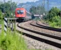 Bild: Matthias Balk/dpa
Ein österreichischer Zug auf der alten Bahnstrecke Rosenheim - Kufstein im bayerischen Inntal. Die DB plant den Neubau mit einem gigantischen Puffer für Inflation und sonstige Risiken. (Archiv)