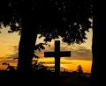 Bild: Moritz Frankenberg/dpa
Der Himmel hinter einem Kreuz strahlt kurz vor Sonnenaufgang orange. Friedhöfe sind für viele Angehörige ein besonderer Ort der Trauer.