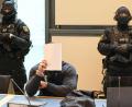 Bild: Peter Gercke/dpa
Der Angeklagte sitzt im Gerichtssaal des Landgerichts Magdeburg zwischen zwei Justizbeamten.