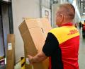 Bild: Sebastian Christoph Gollnow/dpa
Ein Paketbote schleppt in einem DHL-Standort ein schweres Paket. (Archivbild)