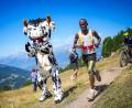 Bild: Maxime Schmid/KEYSTONE/dpa
Philemon Ombogo Kiriago beim 53. Sierre-Zinal-Berglauf: Fan in Kuh-Kostüm sorgt für tierische Unterstützung