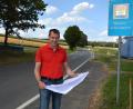 Bild: Josef Rosner
Bürgermeister Andreas Malzer mit den Plänen zur Wasserleitungserneuerung in Groppenheim, im Hintergrund die Kreisstraße TIR 15 in Richtung Münchenreuth, die ab Montag, 17. August, komplett gesperrt sein wird.