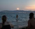 Bild: Clara Margais/dpa
Eine Frau badet im Meer und weitere beobachten die totale Sonnenfinsternis am Strand von Palma.