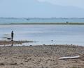 Bild: Karl-Josef Hildenbrand/dpa
Es bleibt heiß in Bayern: Ein Mann steht am trockenen Ufer des Bodensees neben einem Surfboard. (Archivbild)