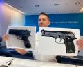 Bild: Sabine Dobel/dpa
Polizeisprecher Thomas Schelshorn zeigt Fotos der Softair-Waffe und der echten Waffe.