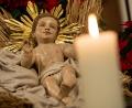 Bild: Sven Hoppe/dpa
In einer Krippe liegt eine Holzfigur von Jesus. Daneben brennt eine Kerze.
