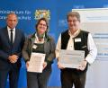 Bild: Astrid Schmidhuber
Umweltminister Thorsten Glauber (links) übergibt die Auszeichnung an Erika und Günter Sauer.