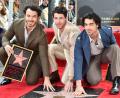 Bild: Jordan Strauss/Invision via AP/dpa
US-Sänger Kevin Jonas (l) hat eigenen Angaben zufolge seinen Brüdern Nick und Joe sowie weiteren Freunden versehentlich ein Nacktfoto geschickt. (Archivbild)