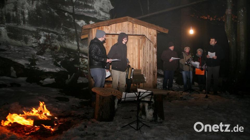 Es ist kalt auf der Felsenbühne. Warme Kleidung und ein prasselndes Lagerfeuer sorgen dafür, dass die Darsteller Andreas Müller und Thomas Beer (von links) sowie die Sänger Martin Betz, Sigrun Hartung und Ramona Baum (in der rechten Bildhälfte von links) nicht frieren müssen. Wolfgang Lang (rechts) fungierte als Erzähler. 	Bild: wro