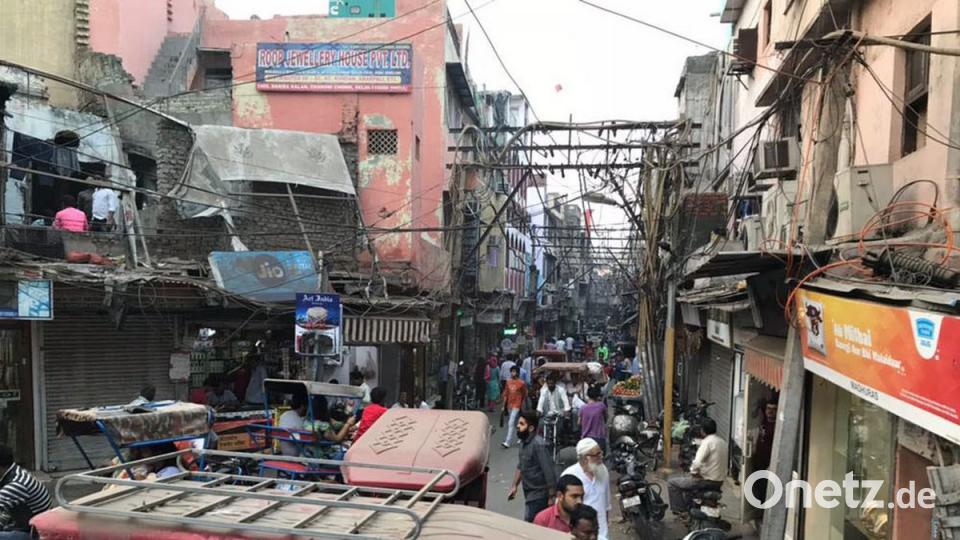 Normaler Betrieb in Delhi (links) und eine Grundschule in Kalakaho (rechts). Die Kinder sitzen auf dem Boden auf Decken, es gibt weder Bänke, Stühle noch eine Tafel. (Bild rechts)