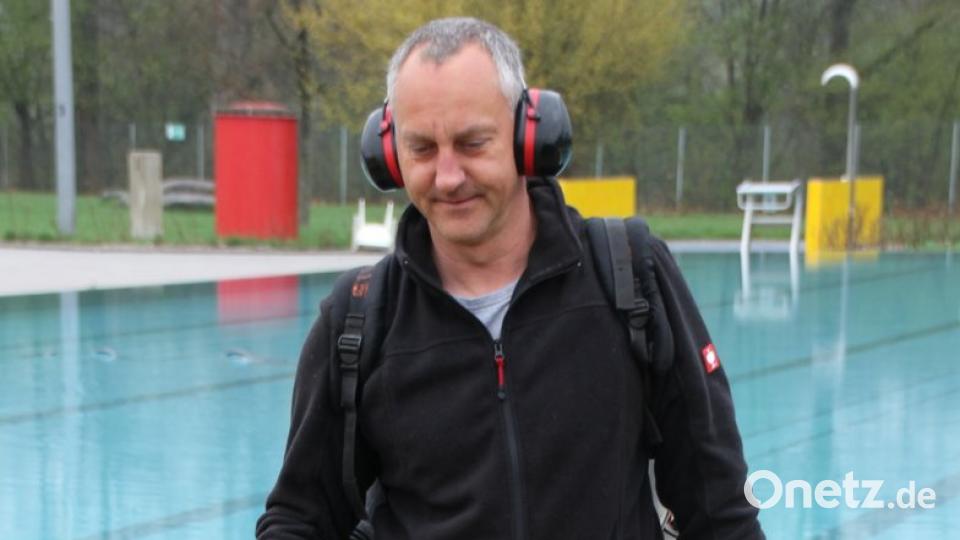 Der neue Bademeister Karl Goldbach reinigt die Außenanlagen mit dem Laubbläser.