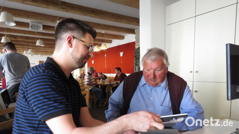 Christian Kubitschek zeigt dem "Holzmichl" aus Waldershof (v. li.), wie er mit dem neuen, modernen Lesegerät technisch gut zurechtkommen kann.