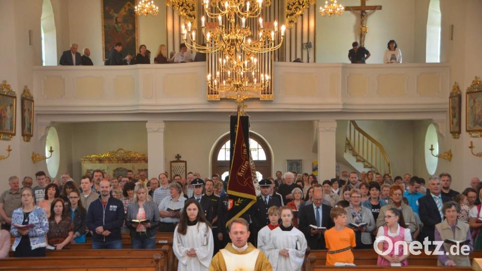 Dekan Alexander Hösl zieht mit den Fahnenabordnungen der örtlichen Vereine in das festlich geschmückte Gotteshaus ein.  	Bild: dob