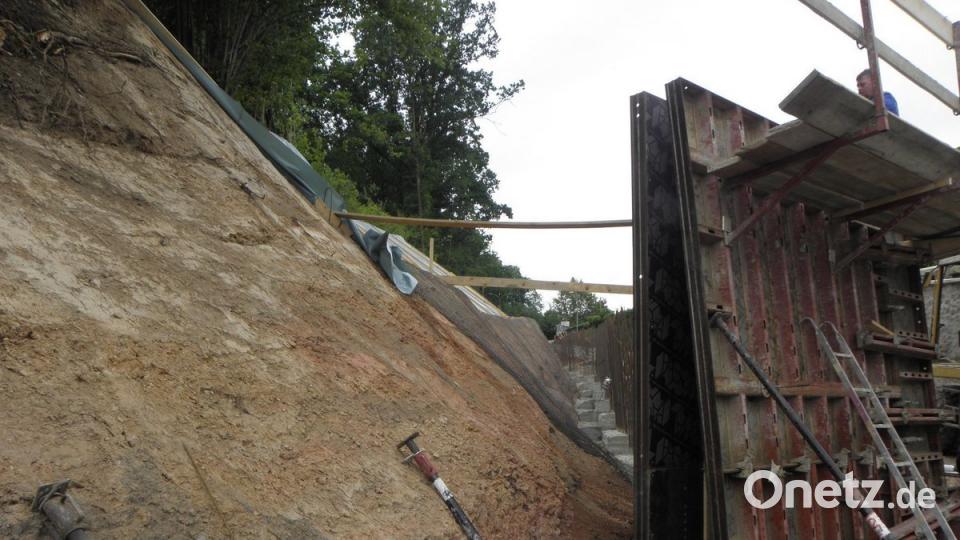 Bevor die Schalung (rechts) für die Mauer aufgebaut werden konnte, bedurfte es erst einer aufwendigen Hangsicherung.