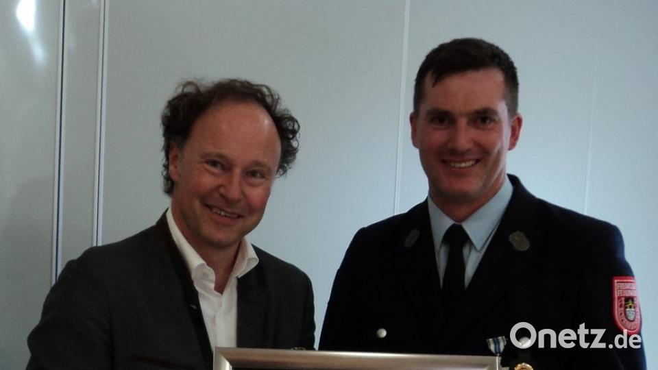 Vorstand Andreas Obermeier überreicht an René Guhl ein Bild vom 150 jährigen Feuerwehrfest