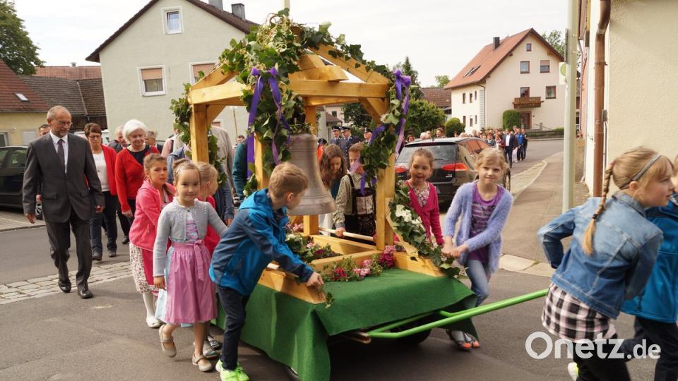 Mit Muskelkraft ziehen und schieben die Kinder die 177 Kilogramm schwere Glocke durch Püchersreuth.  	Bilder: arw (2)