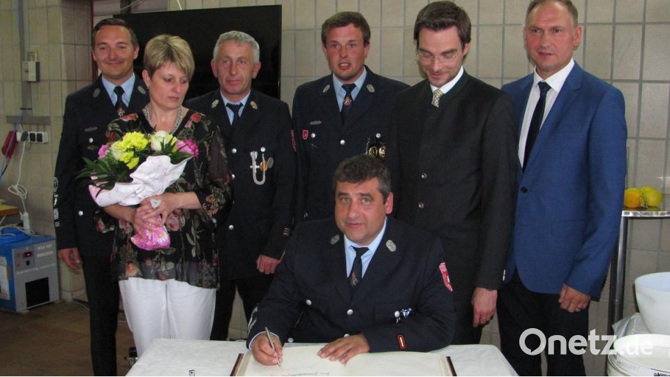 Siegfried Janner (sitzend) darf sich ins Goldene Buch des Markts Mantel eintragen. Er ist seit 20 Jahren Feuerwehr-Kommandant.  	Bild: sei