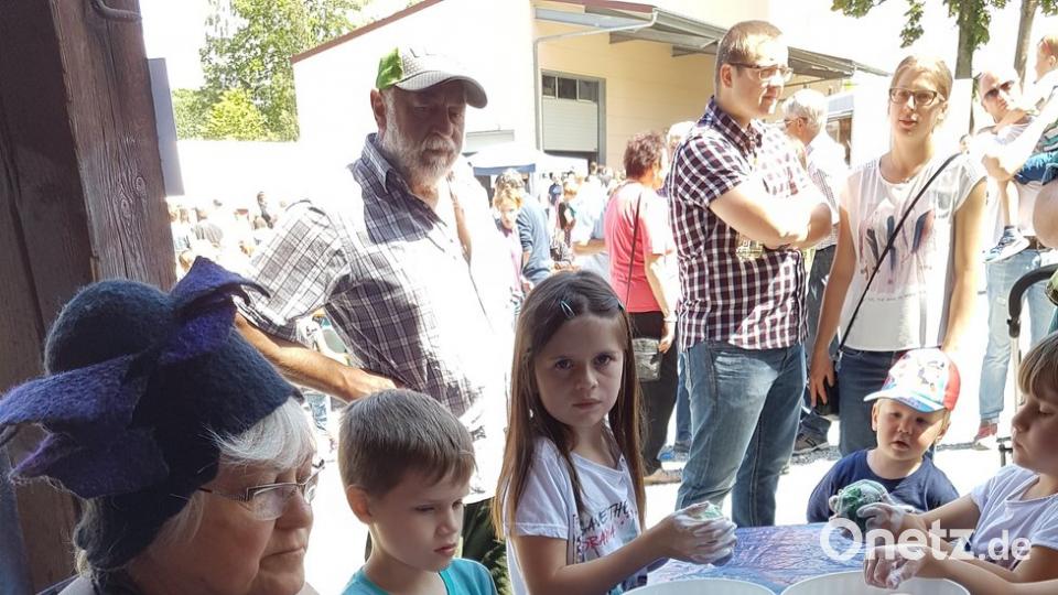 Eine Filzerin zeigt den Kindern, wie aus gefärbter Schafwolle bunte Filzkugeln entstehen. Die neugierigen Kleinen dürfen selbst ausprobieren.