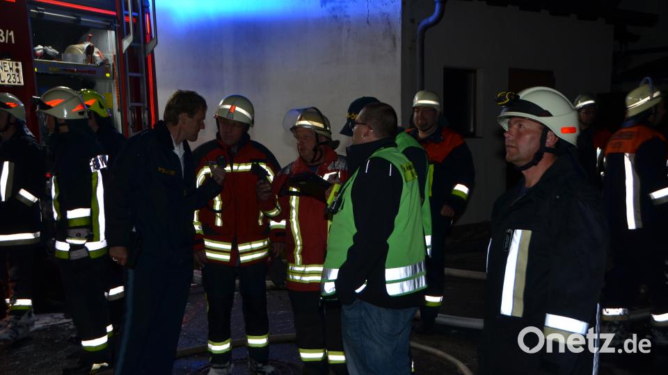 Polizeihauptkommissar Stefan Seuß (links) holt sich erste Informationen von den Feuerwehrkräften. dob