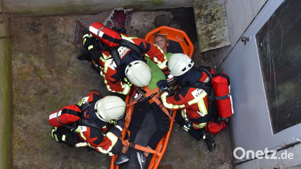 Mit der Schaufeltrage retten die Atemschutzträger eine Person aus dem Fluchtschacht. mde