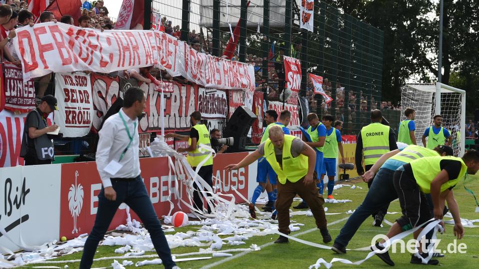 SV Drochtersen/Assel gegen Bayern München: Ordner säubern das Spielfeld, nachdem Bayern-Fans durch Werfen von Plastikbällen und Toilettenpapierrollen für eine Spielunterbrechung sorgten. Bild: Carmen Jaspersen/dpa