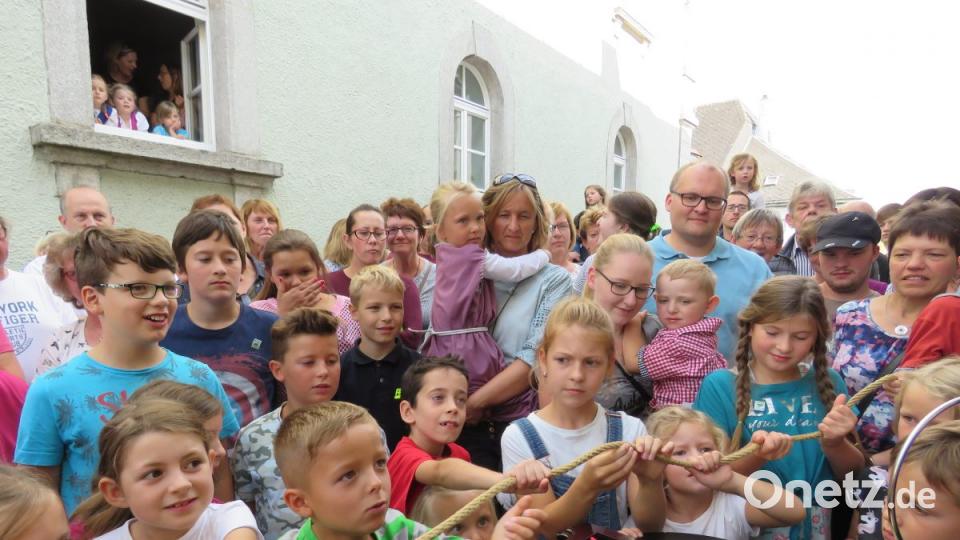 Die Kinder dürfen mitwirken und sind sehr aufgeregt, was mit dem Seil passieren wird. Bild: ubb