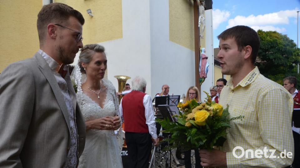 Vor dem Kirchenportal wurde das Brautpaar Katharina Wolfrath und Sebastian Klaszka von zahlreichen Gratulanten in Empfang genommen. Darunter auch der SV Waldau, bei dem der Bräutigam als Co-Trainer fußballerisches Wissen weitergibt. Kassier Thomas Ertl überbringt die Glückwünsche. Bild: dob