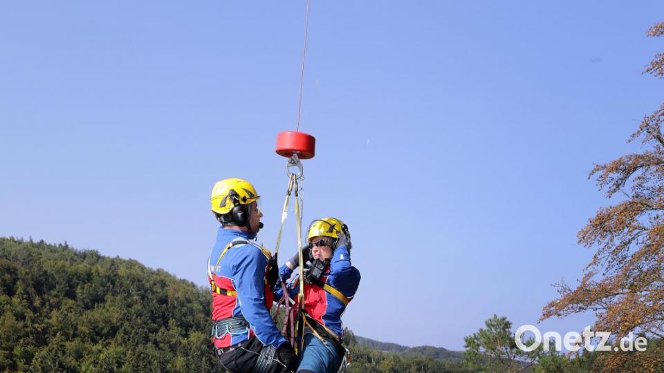 Die Bergretter lassen sich an der Seilwinde an den Felsen hinunter. Dort wartet schon ein verletzter Bergsteiger, der noch in seinen Seilen hängt. Bild: Wolfgang Steinbacher