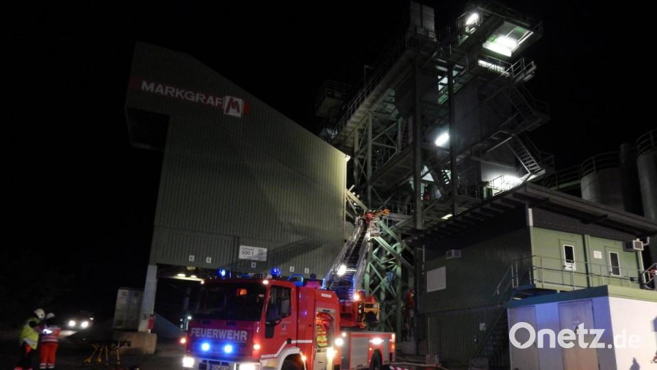 MIt der Drehleiter der Feuerwehr Kemnath wird die Person aus dem Fülltrichter der Asphaltmischanalge gerettet. Bild: mde