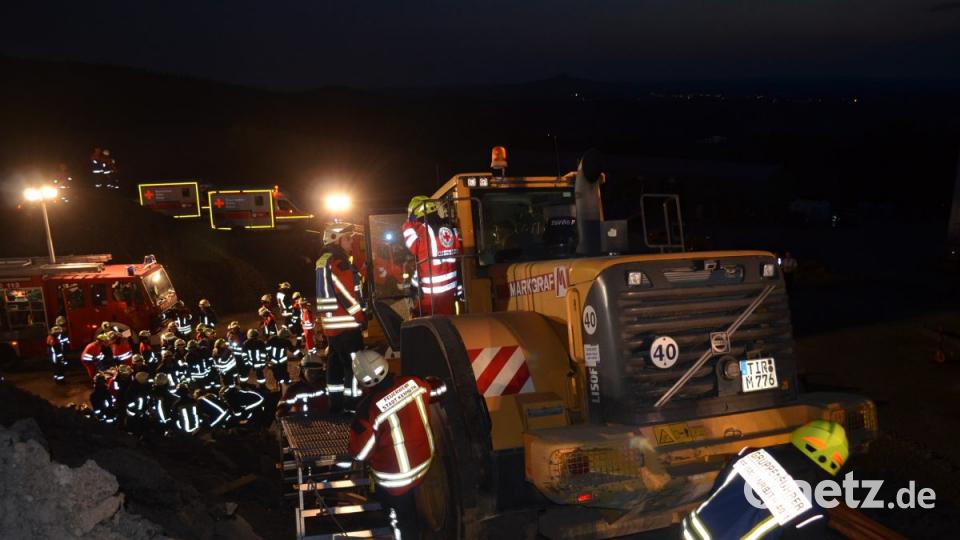 Die Sicherung des Radladers wird fortlaufend kontrolliert. Unterhalb der Absturzstelle des Radladers läuft die Personenbefreiung. In dem Pkw sind zwei Personen verschüttet und im Wrack eingeklemmt. Der Lasterfahrer ist ebenfalls verschüttet. Bild: mde