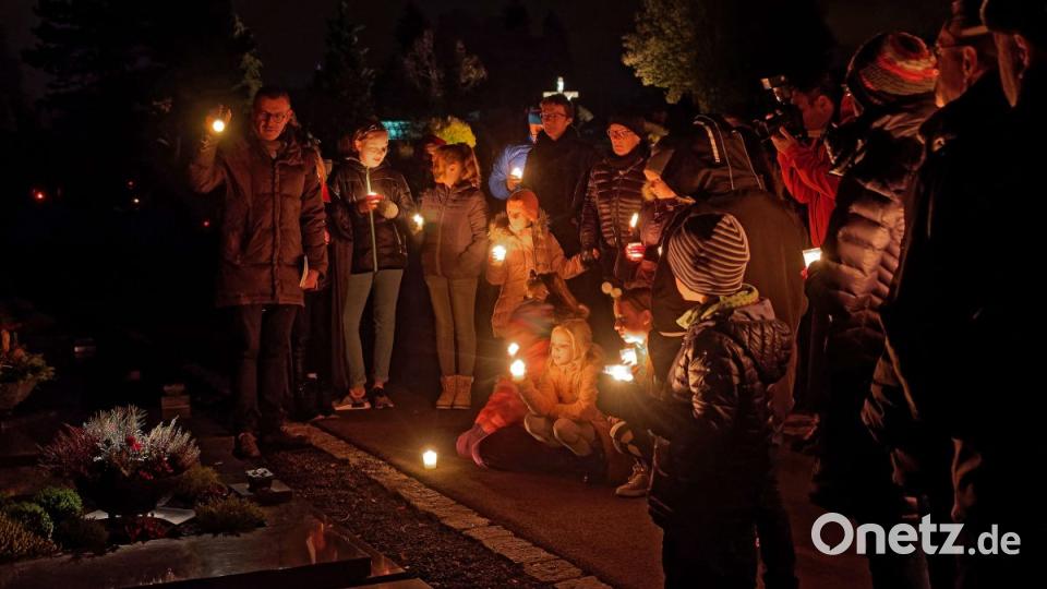 Hier erklärt Pfarrer Thomas Vogl (links) die Symbolik von Blumen auf den Gräbern. Bild: tr