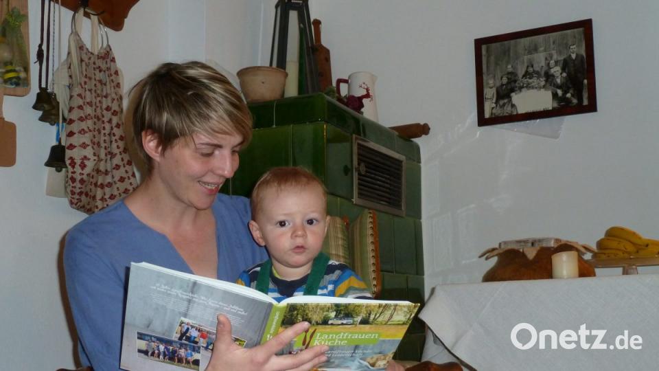 "Schau mal, da ist die Mama!". Barbara Weiherer blättert mit Sohn Emil im Buch der BR-Landfrauenküche 2018. Der ältere Bruder ist im Kindergarten. "Kinder zu haben, das ist für mich eine Erfüllung", sagt die junge Mutter. Bild: Portner