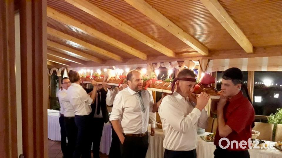 Die jungen, unverheirateten Männer tragen das Backwerk in den Saal. Bild: upl