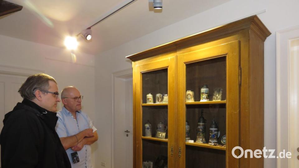 In einem großen Schrank werden Bierkrüge aus Kriegszeiten gezeigt, die ein Sammler als Leihgabe gebracht hat. Bild: ubb