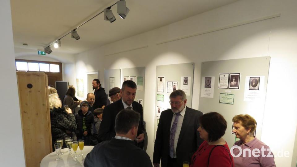 Zahlreiche Gäste wohnten der Ausstellungseröffnung bei und stießen im Flur mit einem Glas Sekt an. Bild: ubb