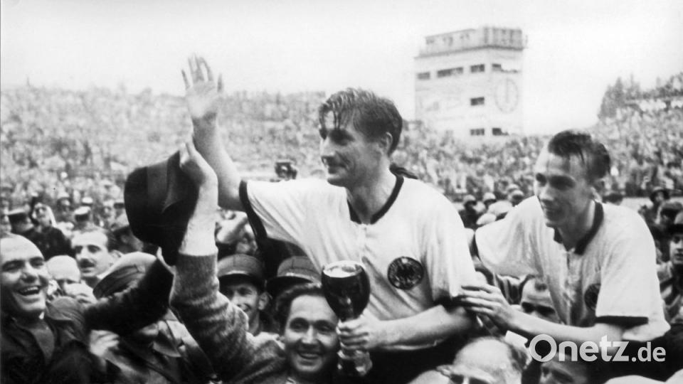 1954: Stürmer und Kapitän Fritz Walter (M, oben) und sein Teamkollege Horst Eckel (r) werden nach dem Triumph im Fußball-WM-Finale im Wankdorfstadion von begeisterten Anhängern vom Spielfeld getragen. Fritz Walter hält den Jules-Rimet-Pokal in der Hand, den er mit seiner Mannschaft gewinnt. Die deutsche Fußballnationalmannschaft besiegt Ungarn mit 3:2 und sichert sich erstmals den Weltmeistertitel. Bild: agentur_dpa