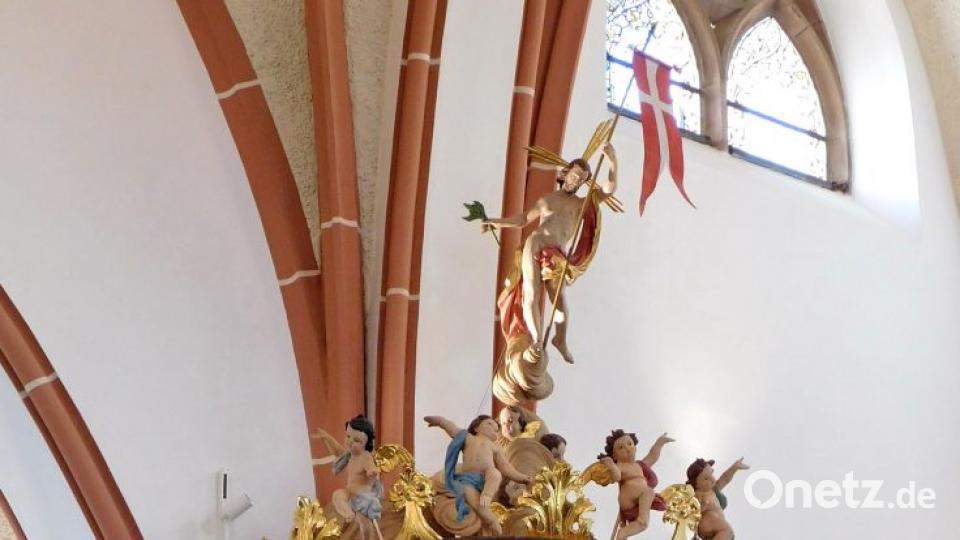 „Sie war schon immer schön, die in neuem Glanz wieder erstrahlende Kanzel“: Dirk Grafe, seit 15 Jahren Pfarrer in Wirbenz, an seinem (neben dem Altar) Lieblingsplatz. Zierten die Engel bislang den Kanzelkorb, so begleiten sie jetzt – dem ursprünglichen Ort entsprechend – auf dem Deckel der Kanzel Christus bei seiner Himmelfahrt. Bild: hai