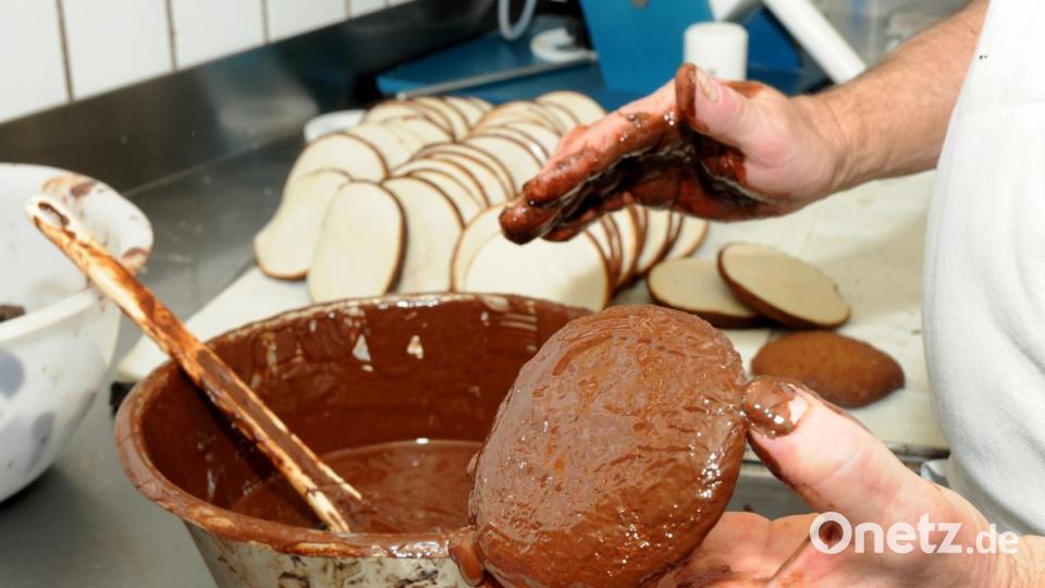 Reine Handarbeit: Der Lebkuchen wird mit Kuvertüre überzogen. Bild: Stephan Huber