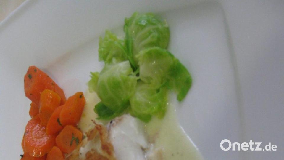 Das Hauptgericht mit Kabeljau in der Brotkruste mit Lauch-Zitronen-Sauce, Nocken-Sternen, glasierten Möhren und Rosenkohlblättern. Bild: Portner